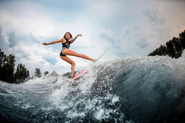 Girl wakesurfer makes stunts on a board