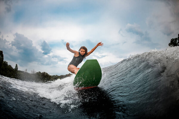 Girl wakesurfer glides smoothly on a board