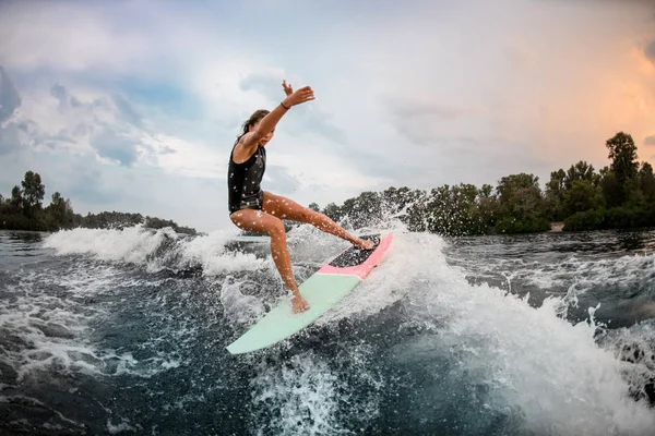 Girl wakesurfer jumping with a surf board — ストック写真