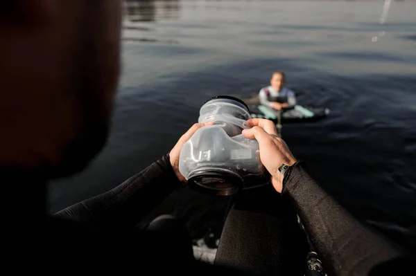 Мужчина-фотограф фотографирует с моторной лодки девушки на волне — стоковое фото