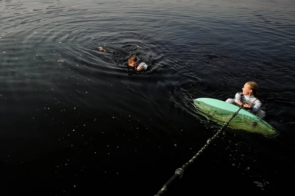 Άντρας φωτογράφος τραβά φωτογραφίες από το νερό του κοριτσιού με ένα wake surf — Φωτογραφία Αρχείου