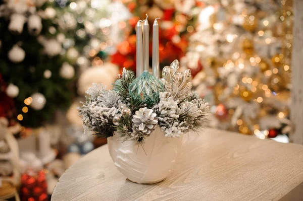 Ваза белого цвета с рождественской композицией декора цветов и свечей — стоковое фото