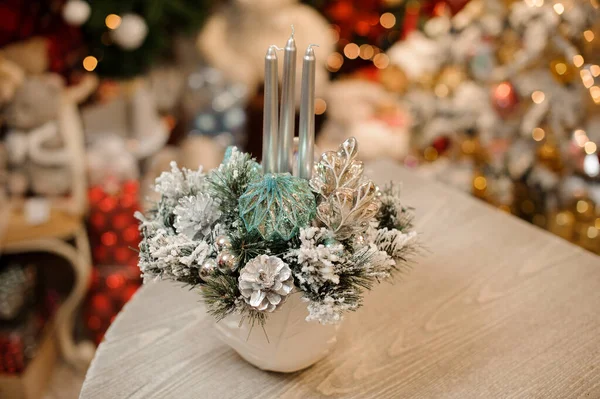 Ваза белого цвета с рождественской композицией декора цветов и свечей на столе — стоковое фото
