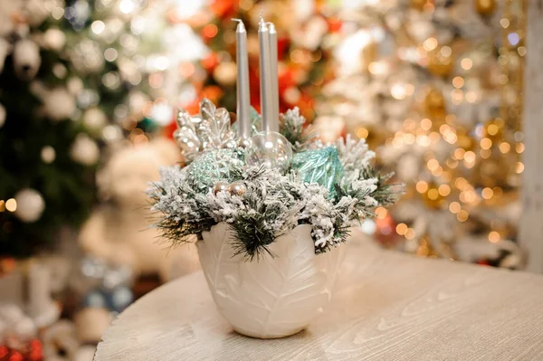 Witte vaas met kerstversiering van bloemen en zilveren kaarsen — Stockfoto