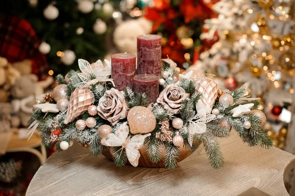 Goudkleurige vaas met kerstversiering van bloemen, speelgoed en drie kaarsen — Stockfoto