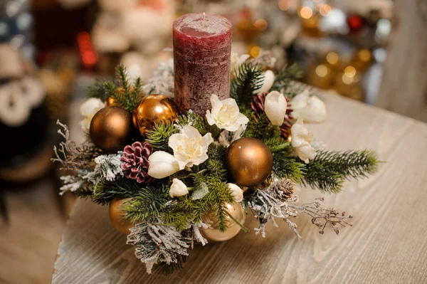 花、おもちゃ、モミの木の枝と1本のキャンドルのクリスマスの装飾組成金色の花瓶の上からの眺め — ストック写真
