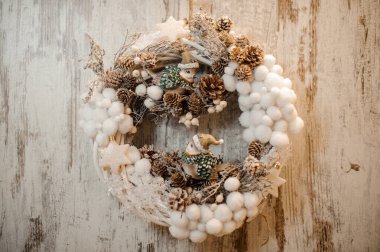 Noel yapay çelengi küçük beyaz pamuk topları, koniler ve oyuncak kuşlarla