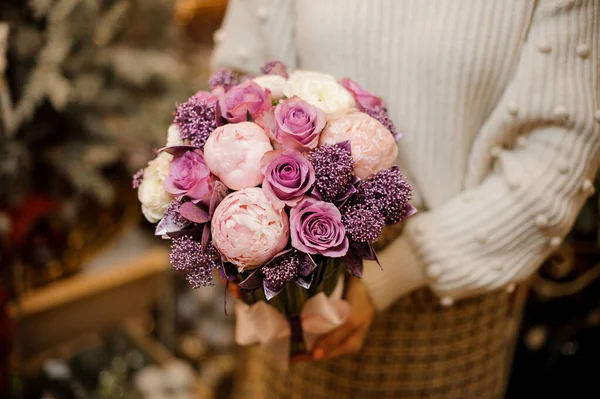 Woman holding a bouquet of tender pink and purple color flowers — Stock Photo, Image