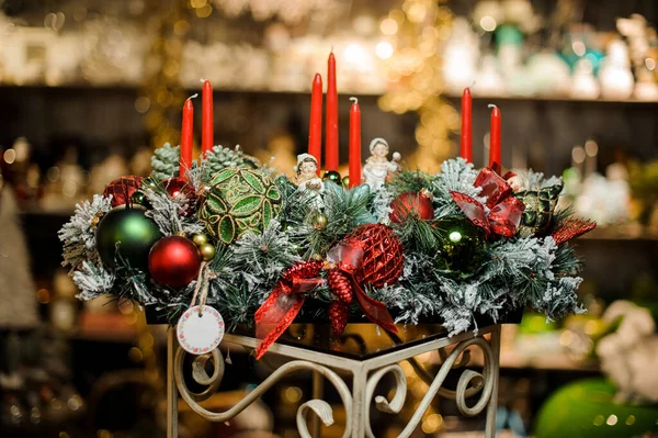 Composição de Natal de ramos de abeto cobertos de neve, velas, fitas, bolas de brinquedos vermelhas e verdes e crianças de brinquedo — Fotografia de Stock