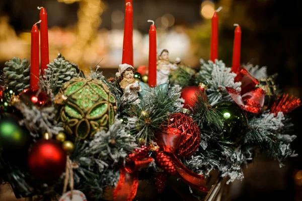 Composición navideña de abeto cubierto de nieve, velas, cintas, pelotas de juguete rojas y verdes y niños de juguete — Foto de Stock