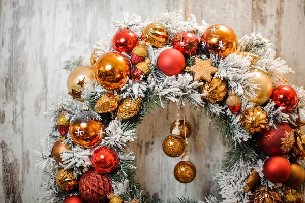Christmas green wreath covered with white snow with golden and red decoration — ストック写真