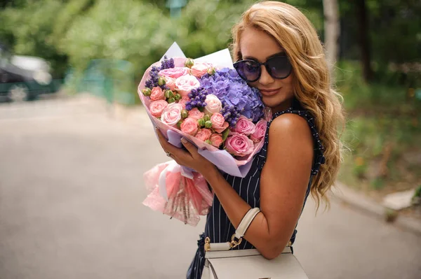 Junge schöne Frau drückt Blumenstrauß fest vor ihr Gesicht. — Stockfoto