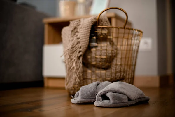View on large metal wicker basket with knitted blanket inside — Stock Photo, Image