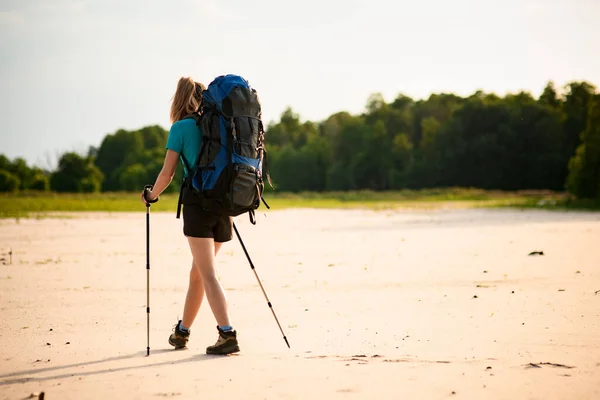 Vue arrière de la femme en tenue de sport qui marche vers la forêt. — Photo