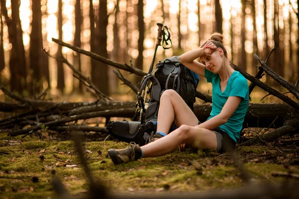 Vue de la jeune femme fatiguée dans la forêt qui est assise près d'un arbre tombé — Photo