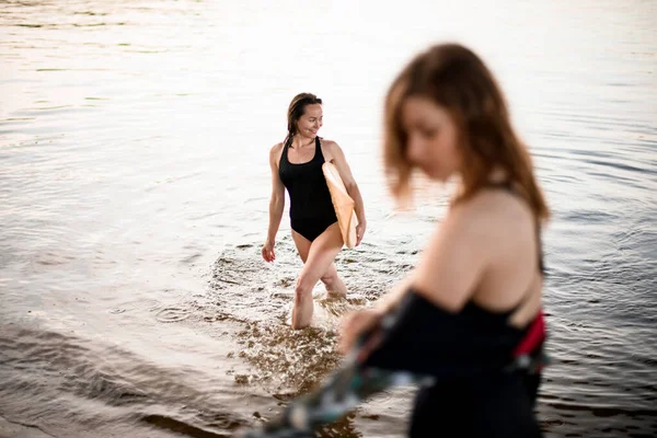 Jonge vrouw in badpak komt uit het water — Stockfoto