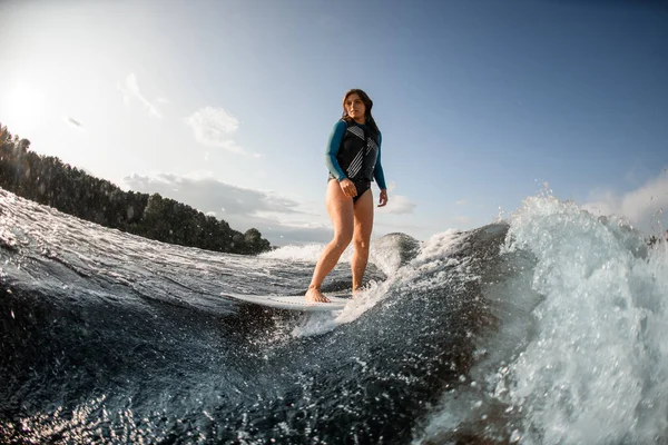 Joven mujer despierta surfeando por las olas del río —  Fotos de Stock