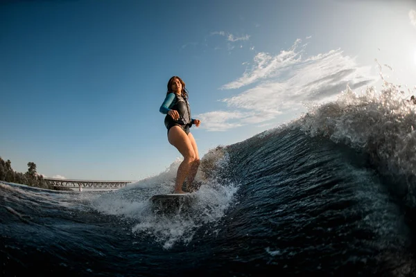 Vue de face de la jeune femme se réveillant sur les vagues de la rivière — Photo