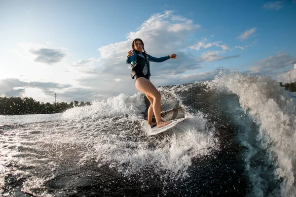 Activa joven mujer despierta surfeando por las olas del río —  Fotos de Stock