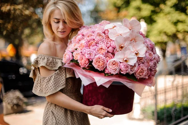 Bela loira mulher segura em suas mãos enorme buquê de flores cor de rosa — Fotografia de Stock