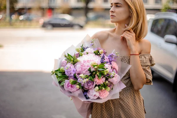 年轻貌美的女人捧着娇嫩的花束 — 图库照片