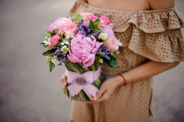 Delicado buquê decorado com fita de cetim nas mãos da mulher . — Fotografia de Stock