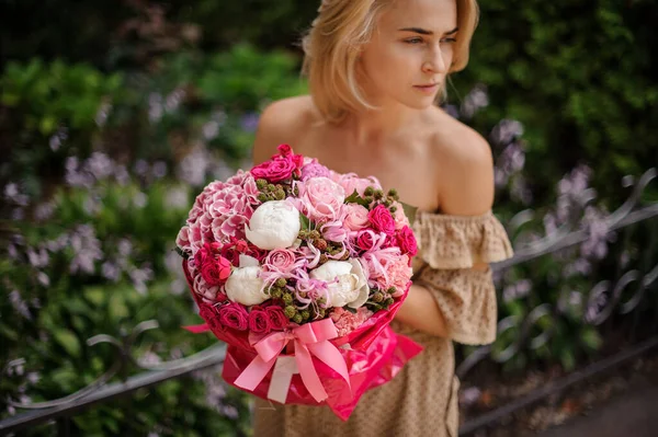Luminoso bouquet rosa di rose e altri fiori nelle mani della donna — Foto Stock