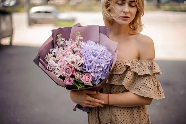 Giovane donna tiene delicato bouquet di ortensie e rose. — Foto Stock