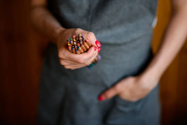 Крупный план цветных карандашей в женской руке — стоковое фото