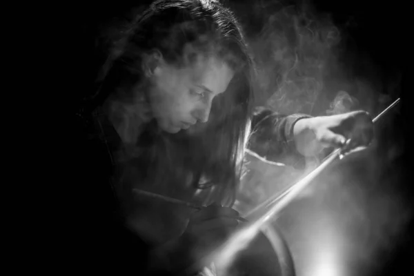 Вид на красиву жінку, яка малює на полотні в темній дим'яній кімнаті — стокове фото