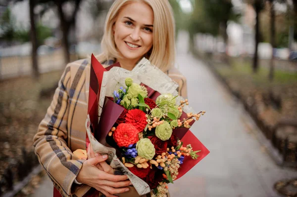 Heureuse femme blonde avec bouquet de fleurs vives dans ses mains — Photo