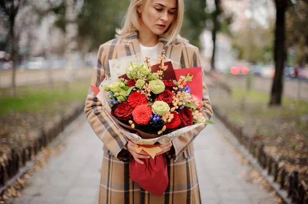 Wanita pirang menarik dengan buket bunga terang di tangannya — Stok Foto