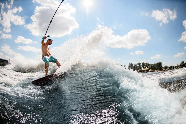 Sporty man wakesurfer catches the wave holding on to the rope — Stock Photo, Image