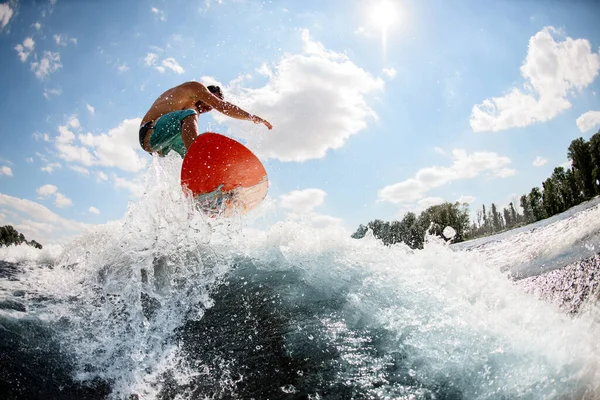 Sport kille hoppar på ljusa wakeboard ner floden mot bakgrunden av himlen — Stockfoto