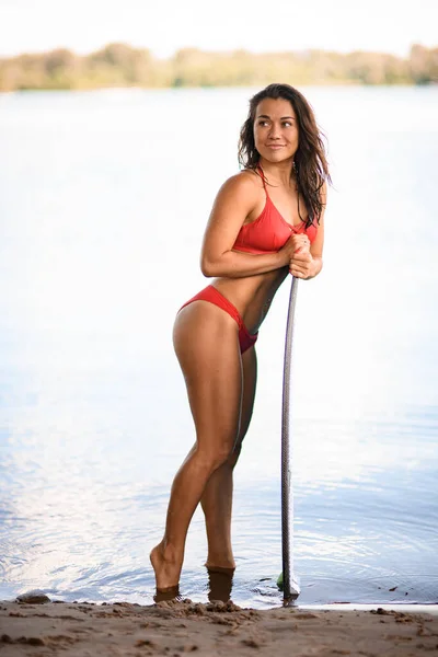 Вид збоку красива жінка, яка спирається на дошку для серфінгу . — стокове фото