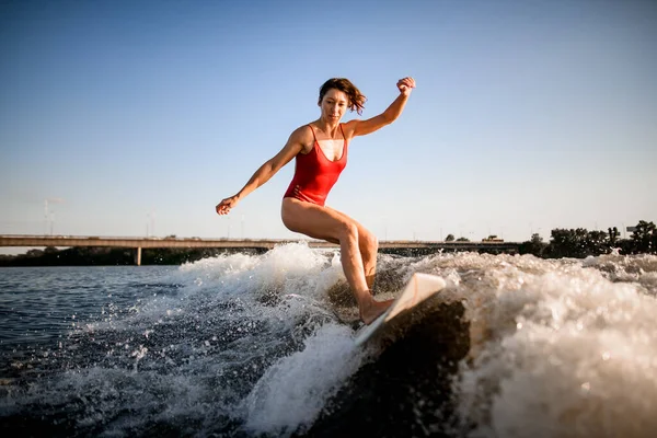 Femme athlétique chevauche magistralement la vague sur planche de surf — Photo