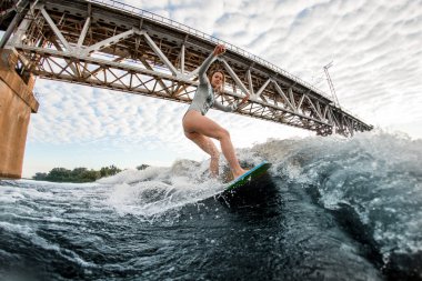 Sörf tahtasında dalgalanan güzel sarışın kadın.