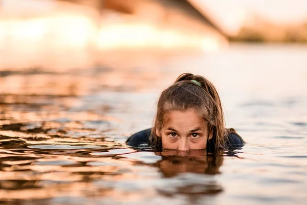 Голова молодой женщины половина выходит из воды — стоковое фото
