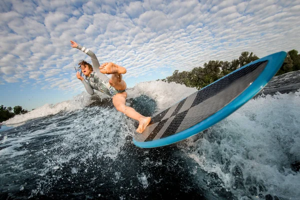 Mujer joven cayendo de la tabla de surf despertar en el agua del río —  Fotos de Stock