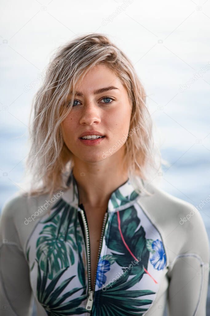 portrait of young attractive blonde woman with wet hair in gray wetsuit