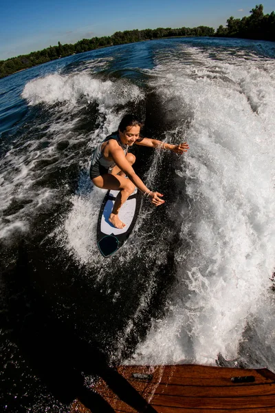 Visão de ângulo alto da mulher que está em pé na placa de wakesurf — Fotografia de Stock