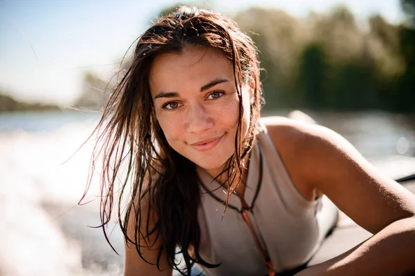 Portret van een mooie vrouw met bruin nat haar op wazig achtergrond strand — Stockfoto