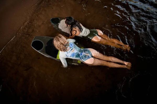 Vista superior de las mujeres en trajes de baño que flotan en el agua del río en las tablas de surf —  Fotos de Stock