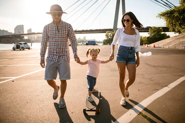 Gelukkig familie paar wandelingen met kind houden haar handen op zonnige zomerdag — Stockfoto