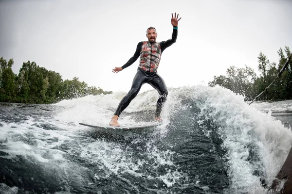 Manlig surfare ridning skummande flod våg från motorbåt — Stockfoto