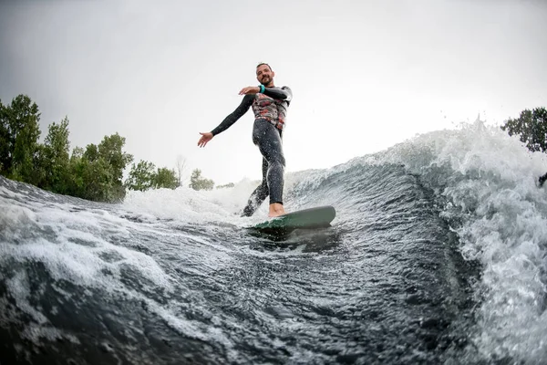 Sportlicher Mann hat Spaß beim Wellenreiten auf Surfbrett am Sommertag — Stockfoto