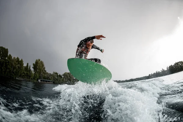 Aktywny człowiek skaczący po jasnej tablicy w dół rzeki — Zdjęcie stockowe