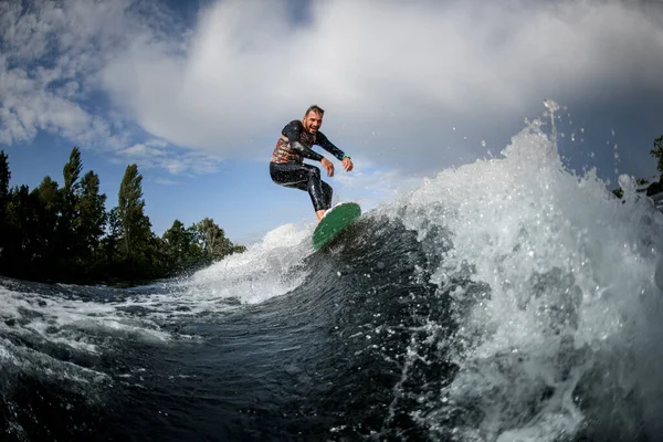 夏の晴れた日に発泡川の波に乗るスポーティ男性サーファー — ストック写真