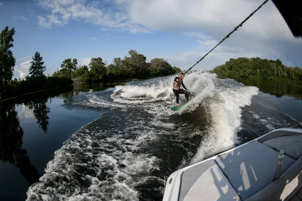Sportos ember lovagol Wakesurf keresztül a hullámok a víz fórumon — Stock Fotó