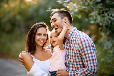 Neşeli anne, baba ve küçük tatlı kızın aile portresi.